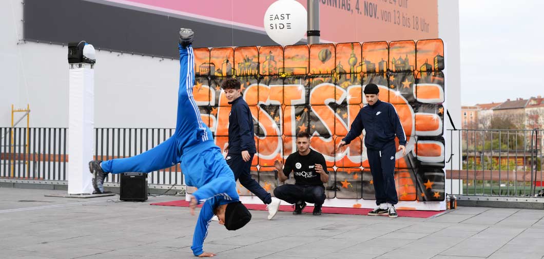 Breakdance Streetdance Show vor der Graffiti Taschenmauer von Urban Artists mit live Graffiti des Eventmotiv und Logo der Veranstaltung
